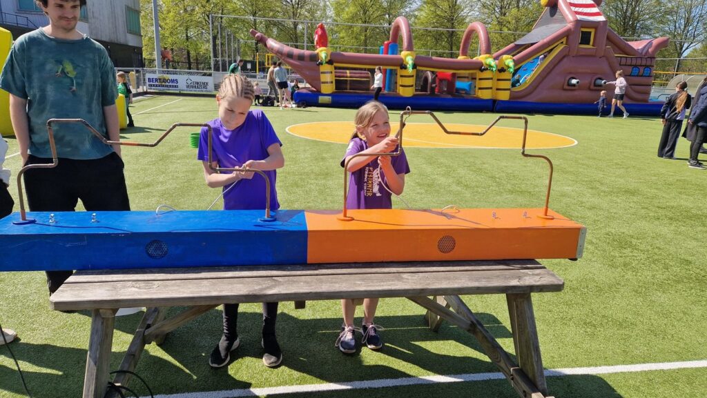 Kinderen spelen een behendigheidsspel tijdens de jubileumdag van ADOS